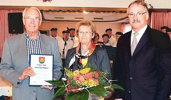 Bürgermeister Bernd Schulte(rechts) überreichte Ernst Weyland eine Urkunde für sein langjähriges sportliches Engagement. Seine Frau Tilla erhielt einen Blumenstrauß. :: Bild: Melanie Jepsen Quelle: nwz-online